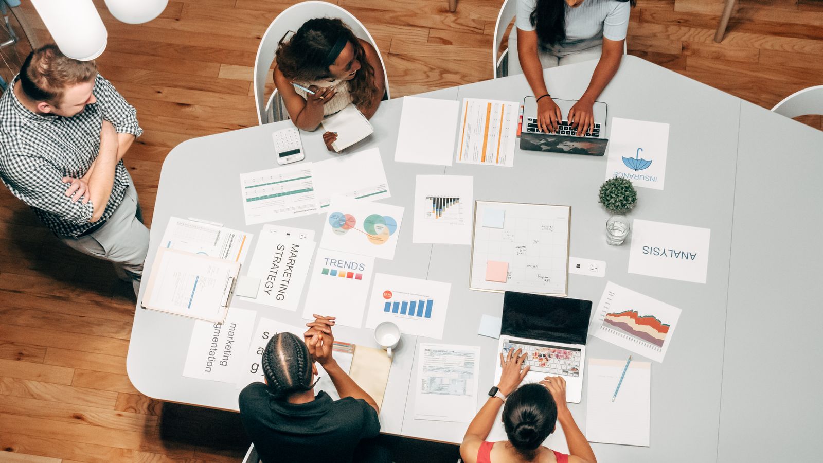 Team auditing marketing strategy charts around a table, diagnosing why a business is not growing online