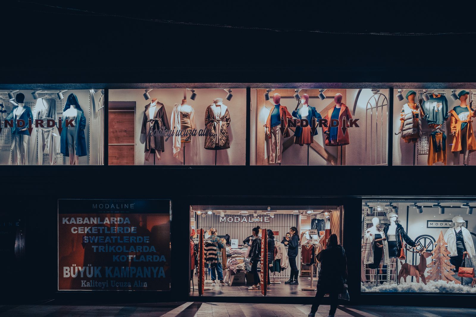 A lit clothing store window with mannequins at night, the window shopping moment retargeting ads are built to follow up on
