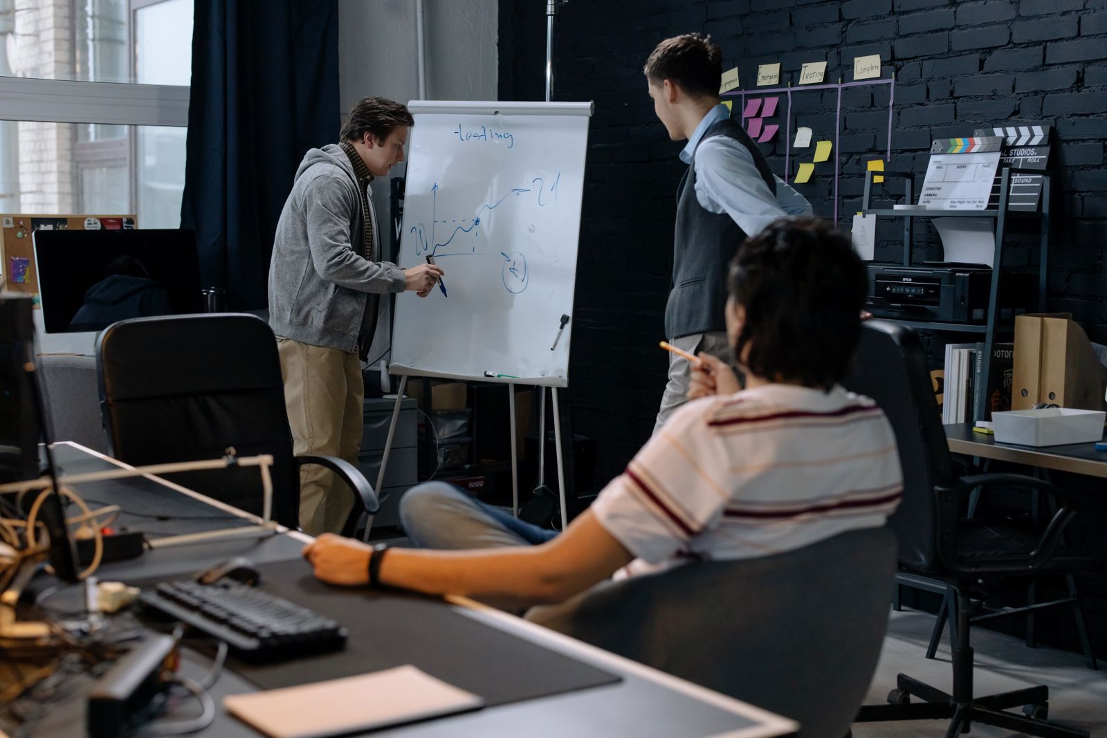 Startup team planning at a whiteboard, sketching the first 90 days of digital marketing for their new company