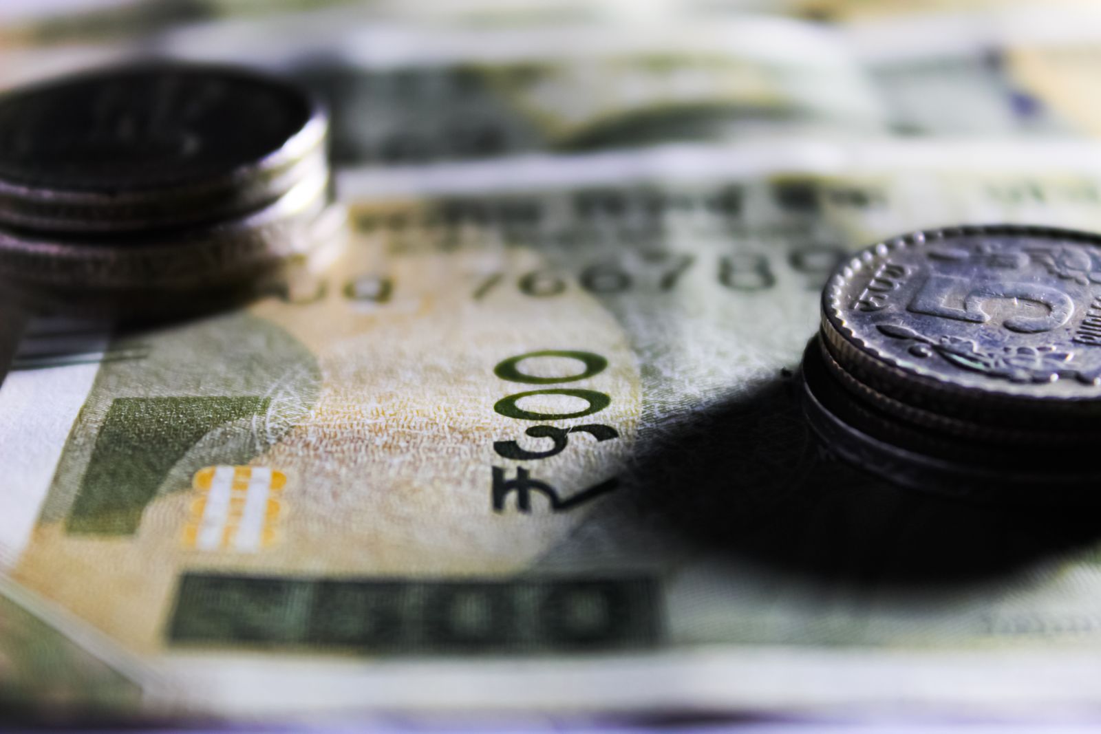 Indian rupee notes and coins on a desk while budgeting website cost in India
